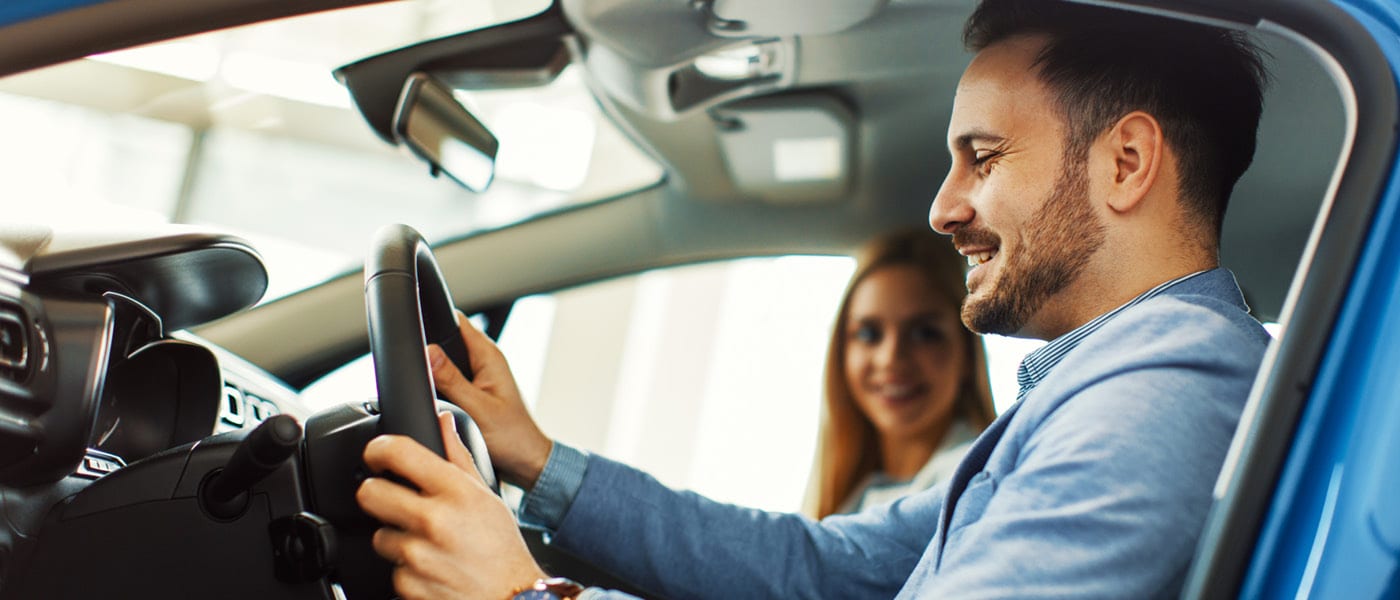 Man testing car with saleswoman