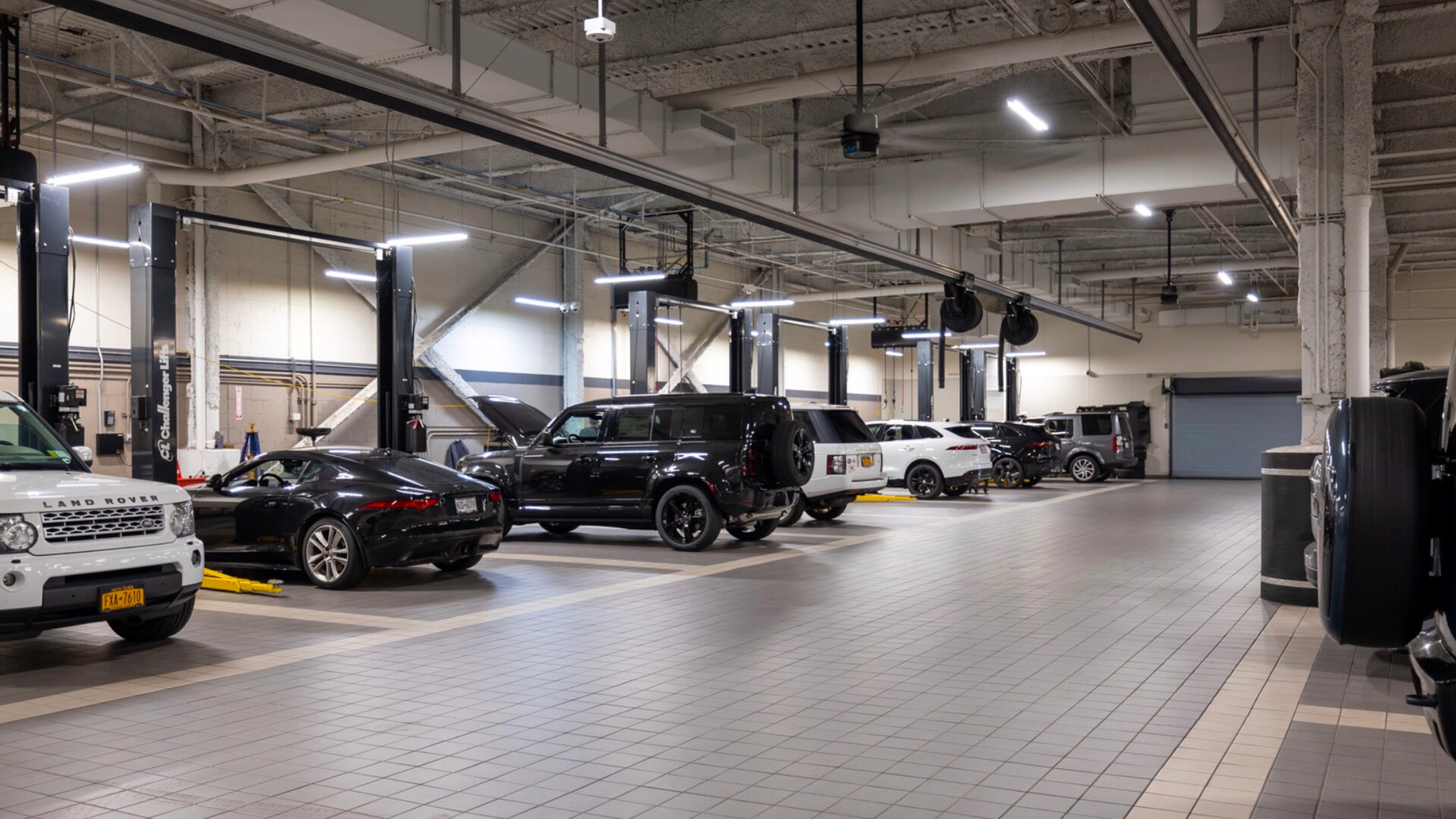 Interior of Land Rover New Rochelle service center. Vehicle service bays are seen with many vehicles ready to be worked on.