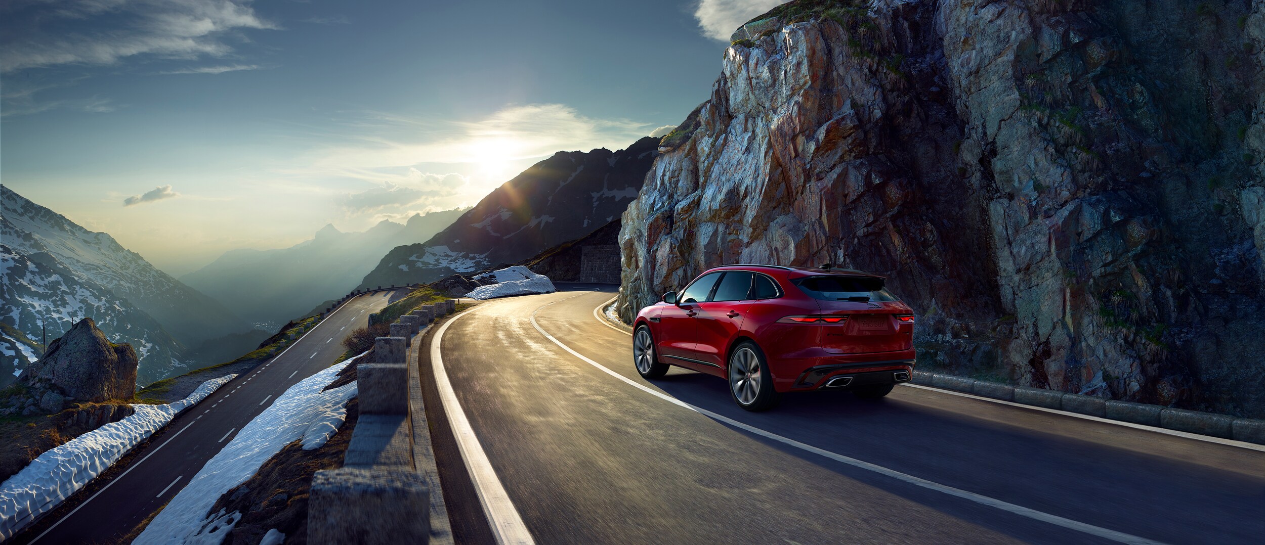 Jaguar F-PACE driving on road through mountains