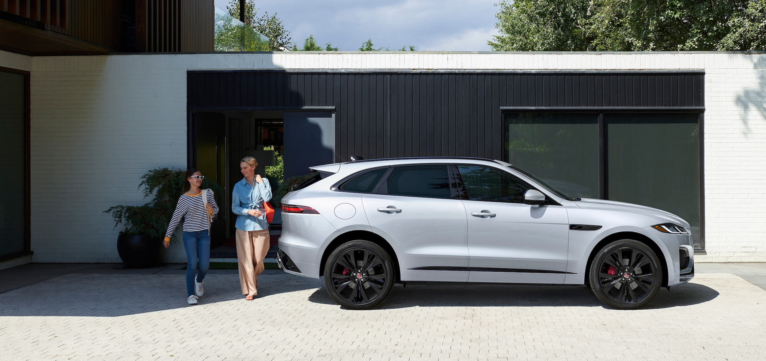 White Jaguar F-PACE parked at home with family