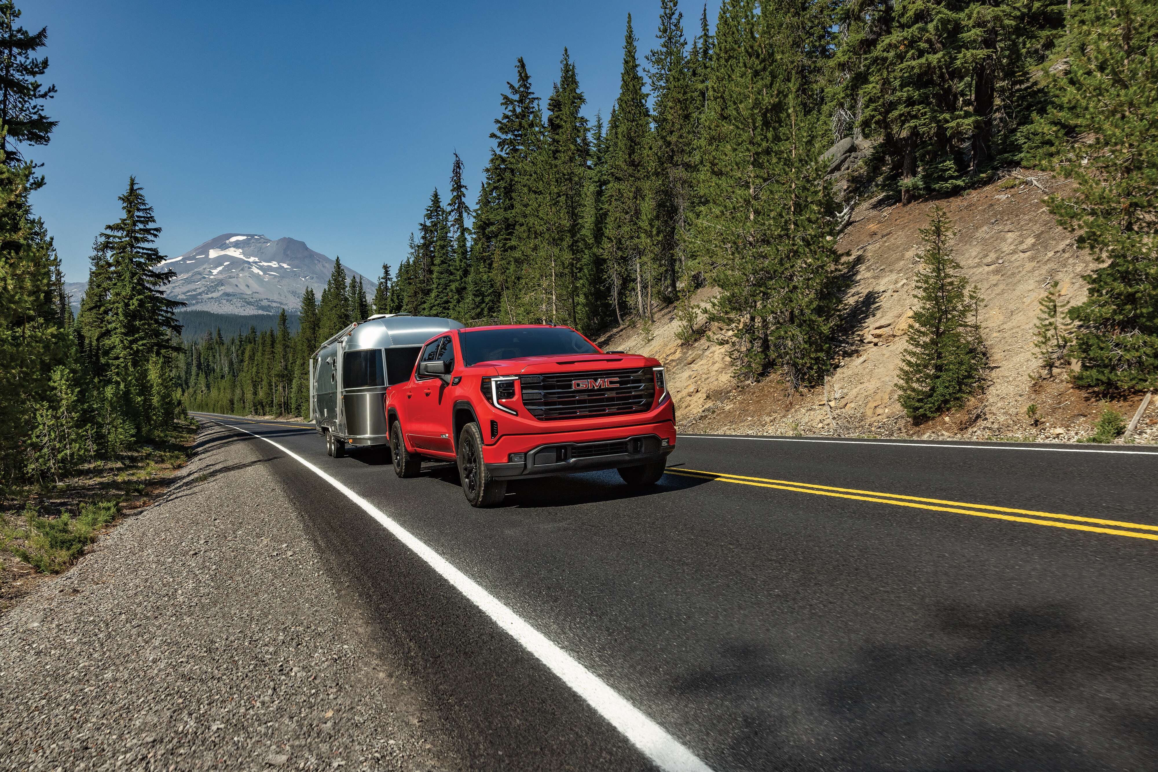 GMC Sierra 1500 GMC Sierra 1500 towing a travel trailer on a mountain road