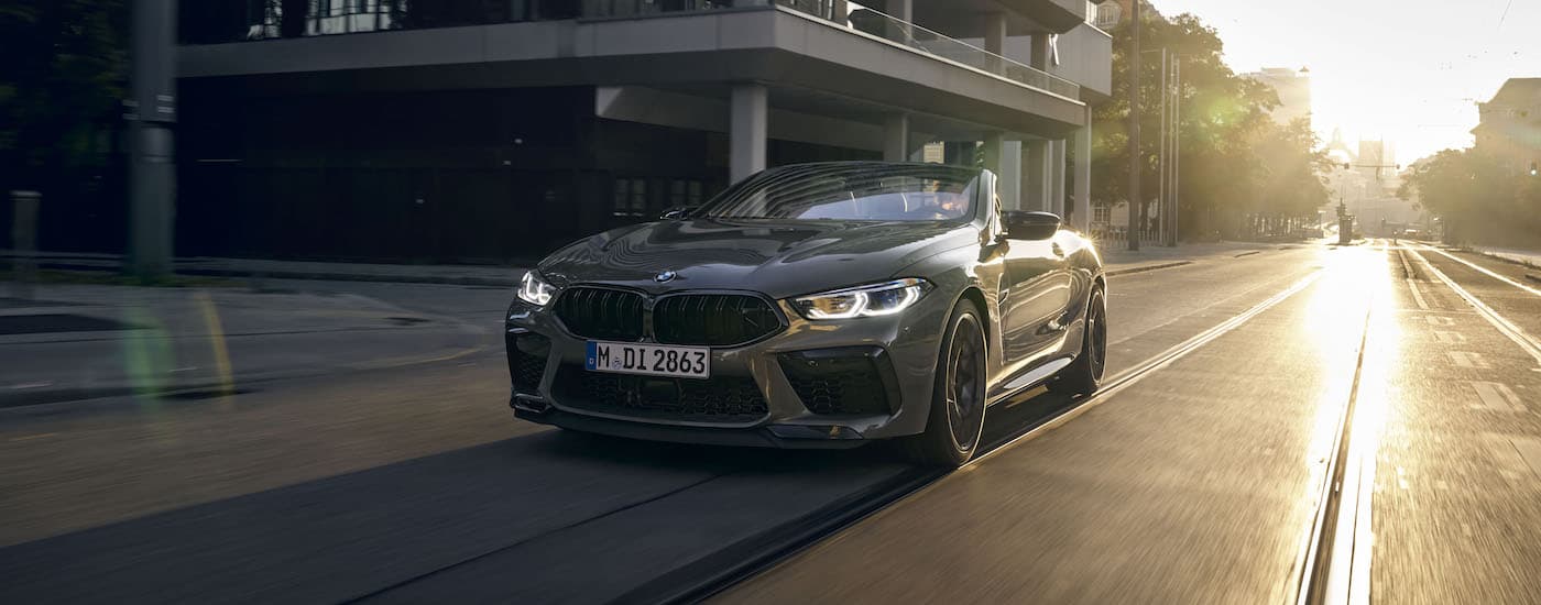 A grey 2022 BMW M8 Competition is shown driving on a city street after leaving a BMW Dealership in Cincinnati Ohio.