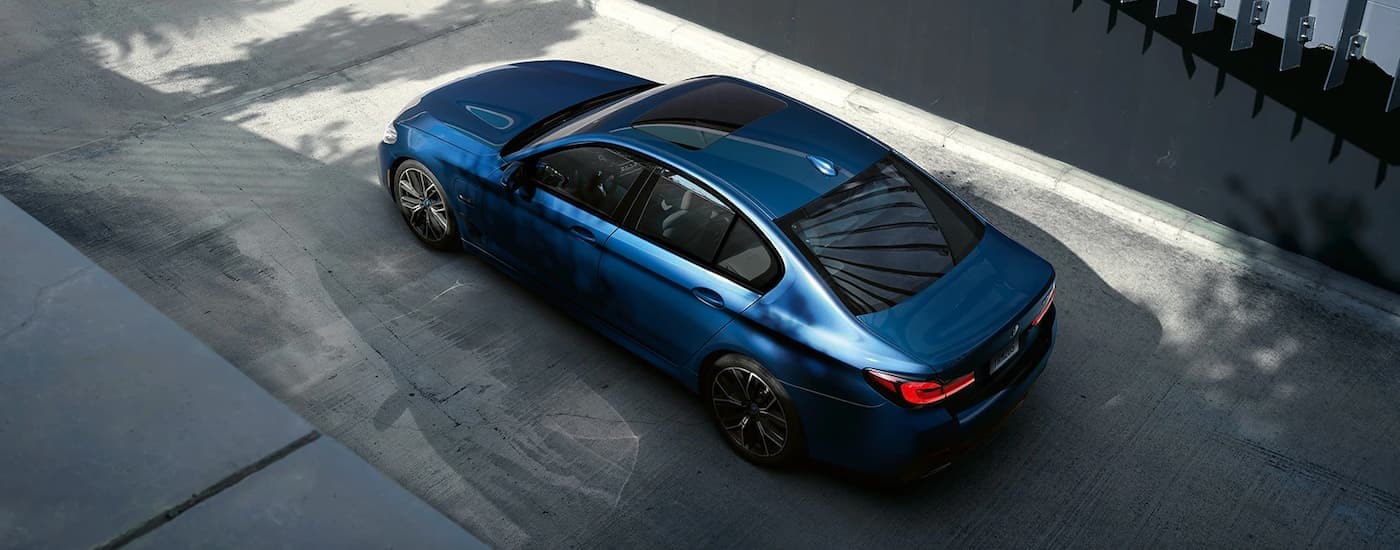 A blue 2021 BMW 5 Series is shown from a high angle on pavement.