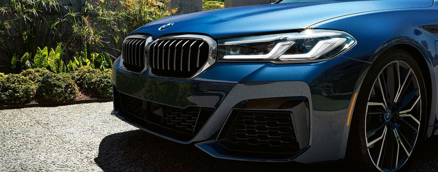 A popular used BMW 5 series for sale, a blue 2021 BMW 5 Series, is shown in close up.