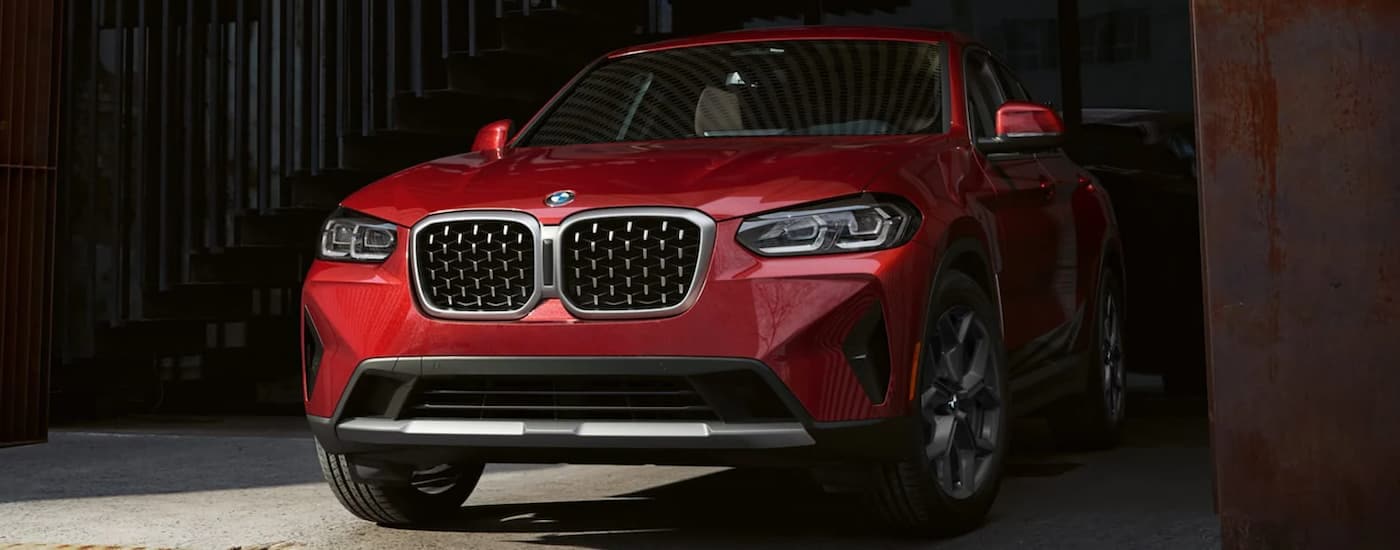 A red 2022 BMW X4 xDrive30i is shown from the front after researching BMW lease deals.
