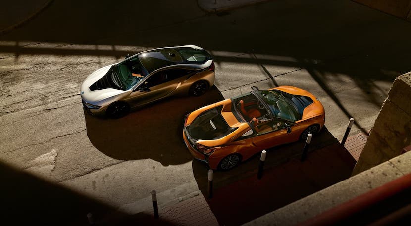  A silver 2021 BMW i8 coupe and an orange i8 convertible are shown from above while parked on a street in Cincinnati, OH.