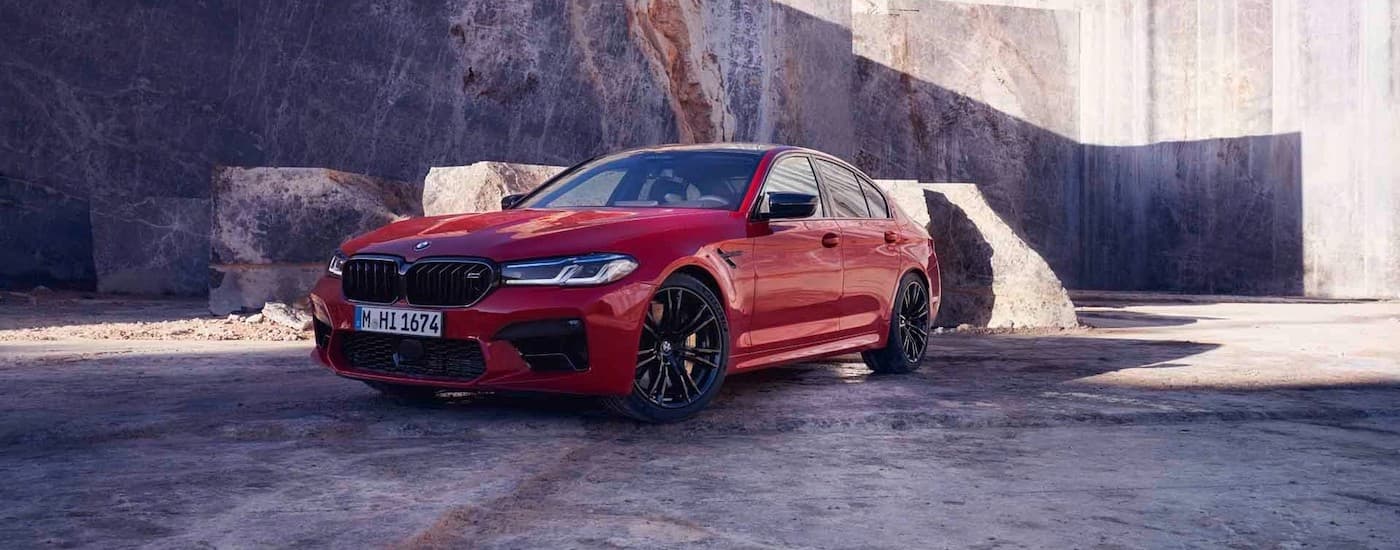 A red 2020 BMW M5 Competition is shown parked in a quarry.