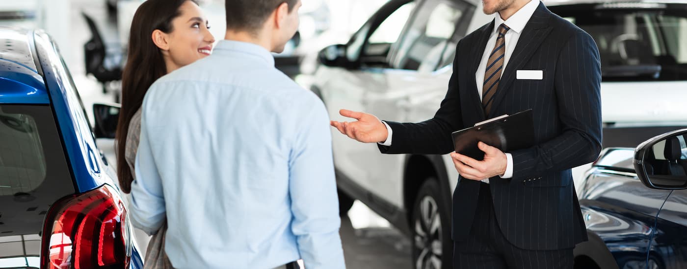A salesman is shown speaking to customers about their vehicle's trade in value.