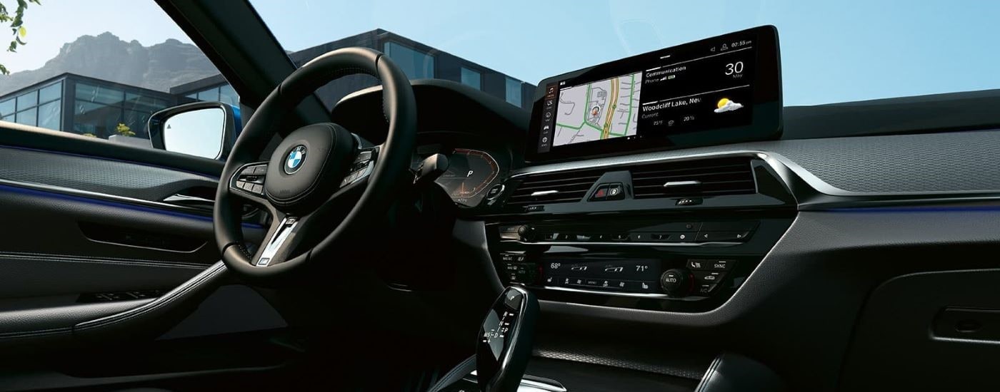 A close up shows the dash and infotainment screen in a  2023 BMW 5 Series.