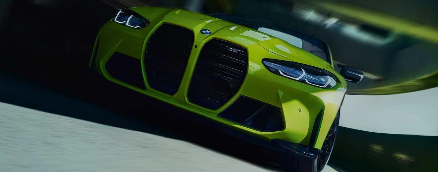 A yellow 2022 BMW M4 is shown from the front after leaving a West Chester BMW dealership.