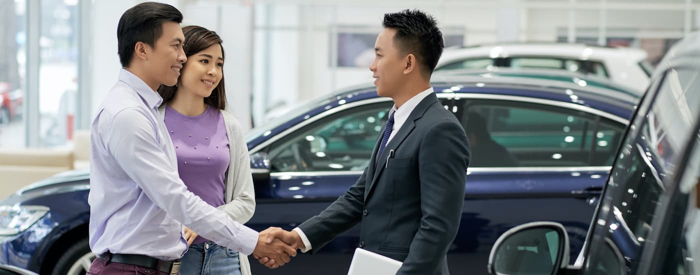 A person is shown shaking a salespersons hand at a BMW dealership in Cincinnati.