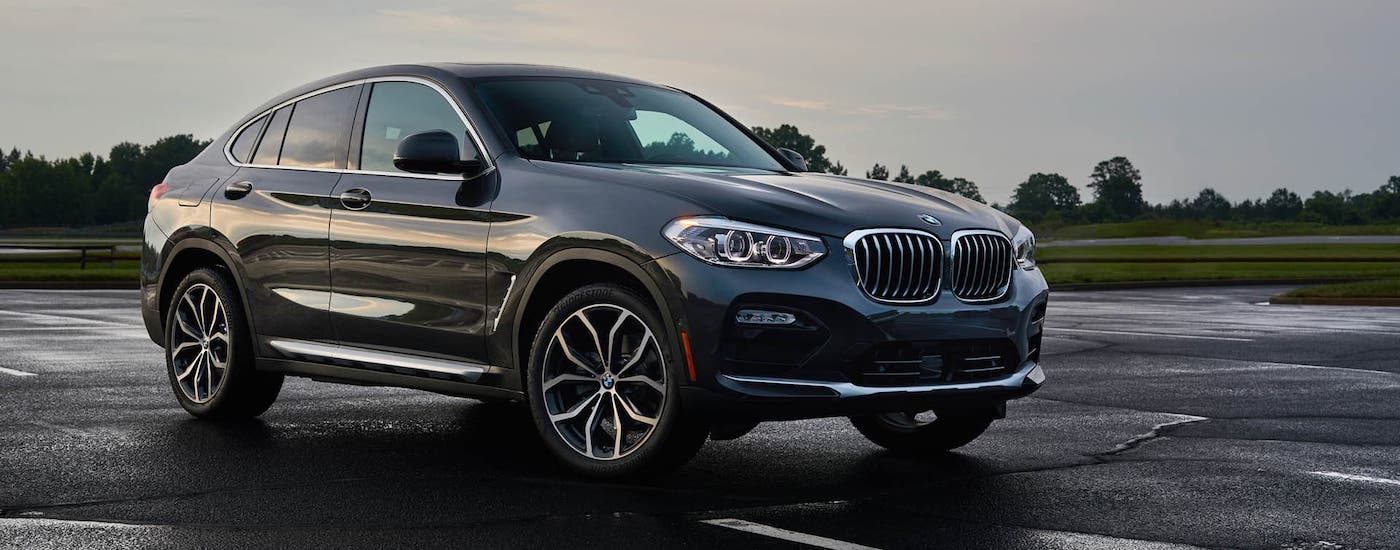 A black 2019 BMW X4 is parked in an empty lot.