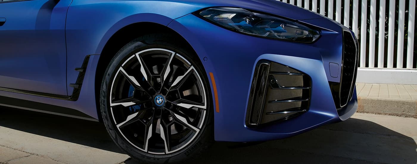 A close up of the front half of a blue 2023 BMW i4 M450 is shown after leaving a BMW i4 dealer.