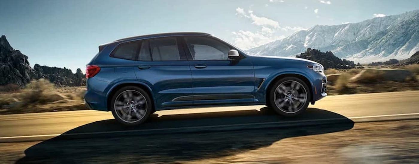 A popular used BMW for sale in Dayton, a blue 2020 BMW X3 is shown from the side.