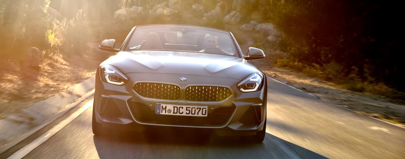 A greay 2021 BMW Z4 M40i roadster is shown driving down a sunny road..