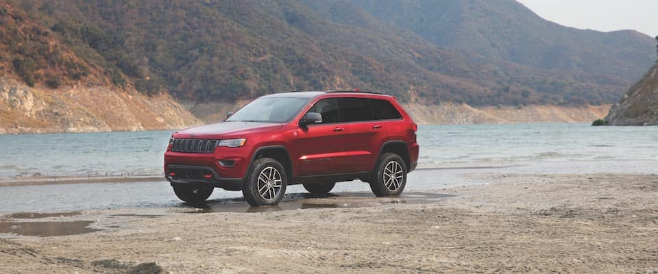 2019 Jeep Cherokee A red 2019 Jeep Cherokee parked near a lake and mountains