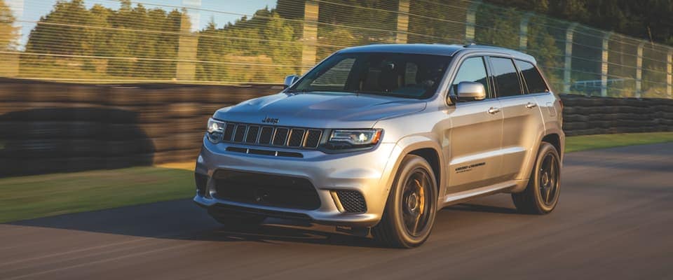 2019 Jeep Grand Cherokee A silver 2019 Jeep Grand Cherokee driving down a track