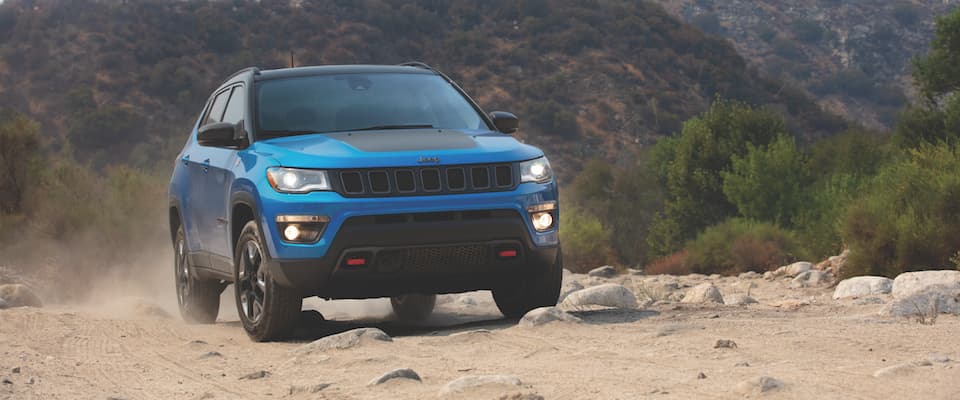 A blue Jeep Compass offroading