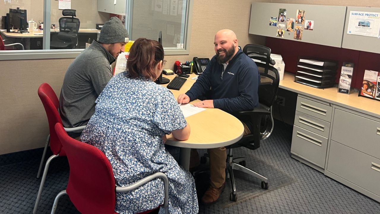 Finance Manager Nick Betker going over paperwork with buyers in the finance office at Jay Malone Ford in Hutchinson, Minnesota