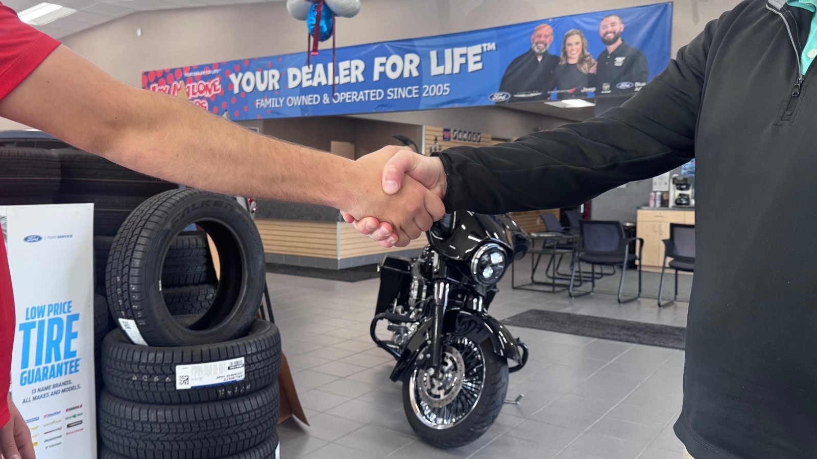 Customer handshake at Jay Malone Motors in Hutchinson, MN with the Malone family in the background