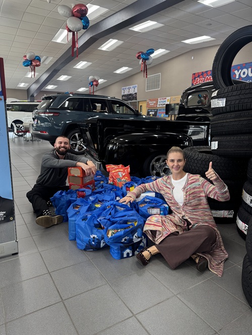 Jake Malone and Jordan Malone-Forst with 296.2 pounds of food collected at Jay Malone Ford for the McLeod Food Shelf during the Ford Global Food Drive