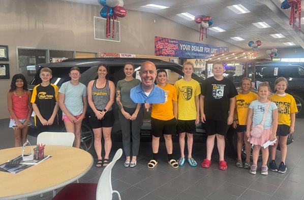 Jay Malone Motors Assistant General Manager Jordan Malone-Forst with young Hutchinson High Tides Club swimmers and their coach