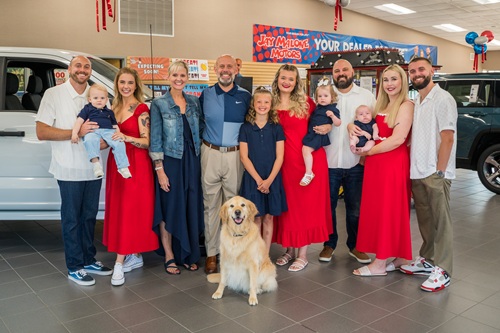 The Malone family and their golden retriever in the showroom at Jay Malone Motors in Hutchinson, MN