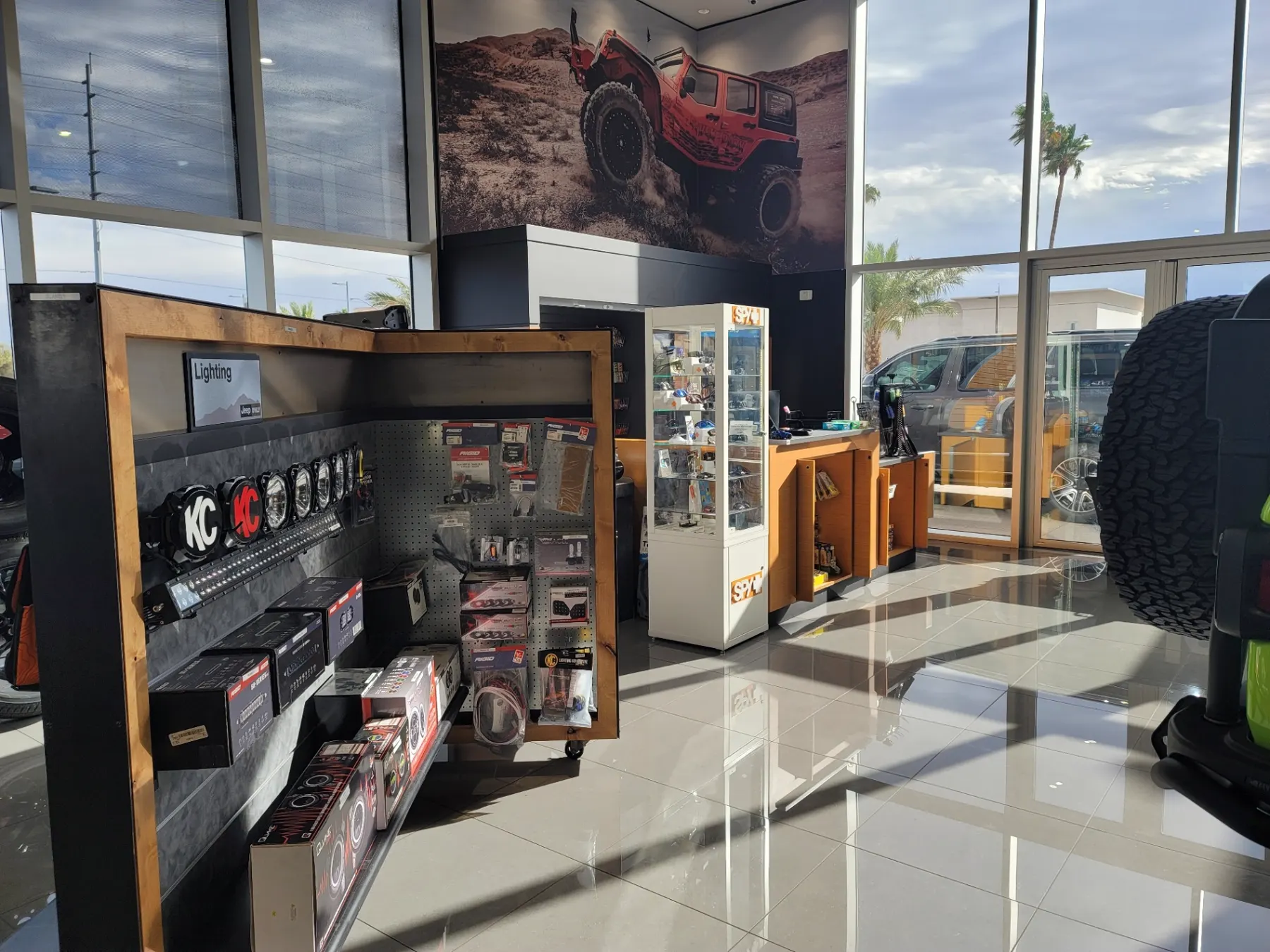 In-store Jeep accessory display with off-road lighting bars, pods, and wiring kits at the Jeep Only parts counter