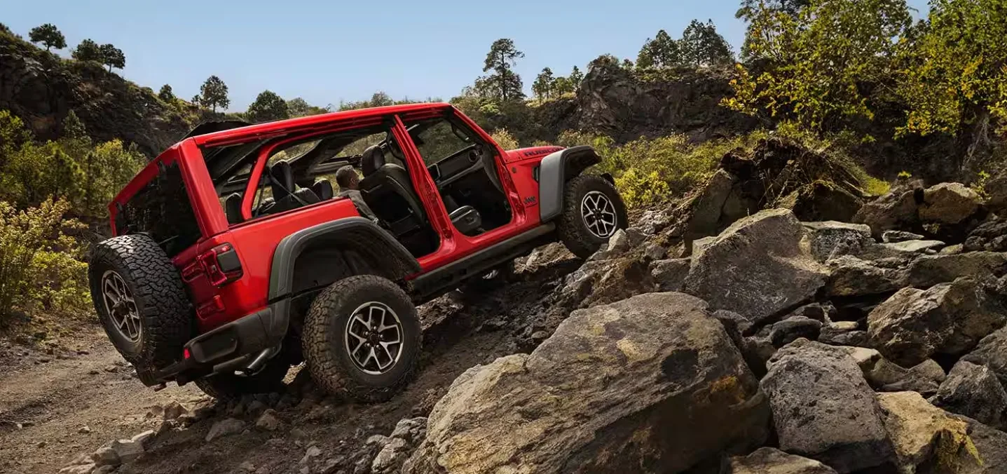 Red Jeep Wrangler Rubicon rock crawling on rugged terrain near Las Vegas