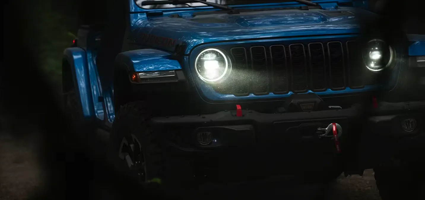 Blue Jeep Wrangler Rubicon with LED headlights on for Jeep shoppers in Las Vegas