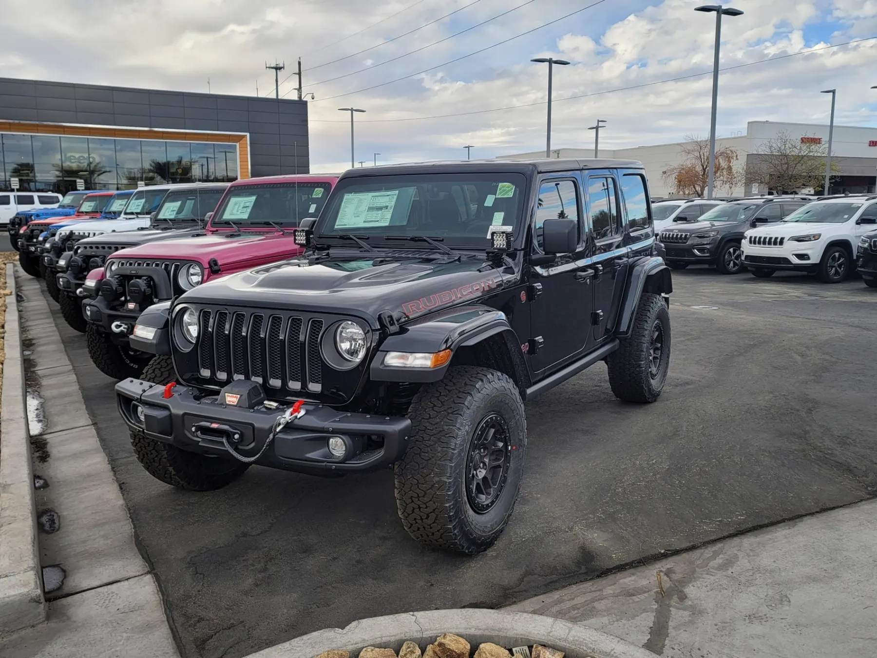 Black Jeep Wrangler Rubicon with a factory winch parked in a row of new Wranglers at Jeep Only in Las Vegas