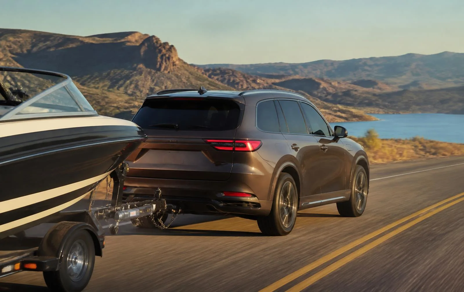 Jeep Grand Cherokee towing a boat on a highway for a towing capability comparison with Toyota 4Runner