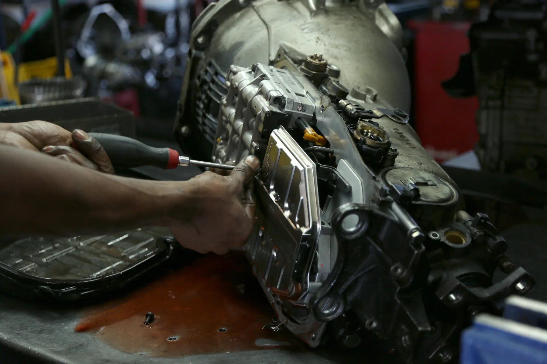 Technician removing the valve body from a transmission during service