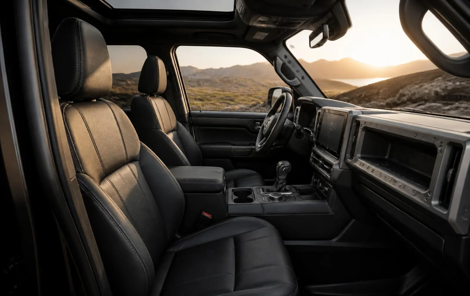 Jeep Wrangler interior with front seats and dashboard technology for a Wrangler vs Bronco comparison