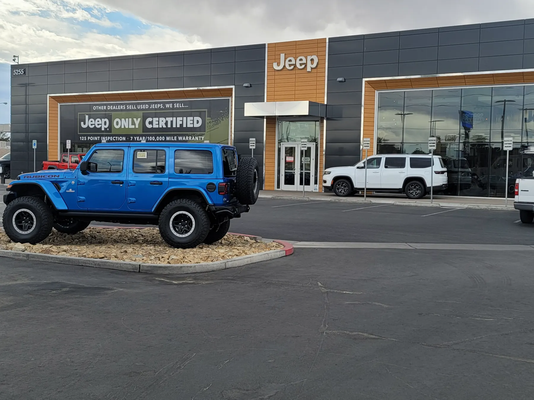 Exterior of the Jeep Only dealership on West Sahara Avenue with a blue Wrangler Rubicon on the entrance display pad