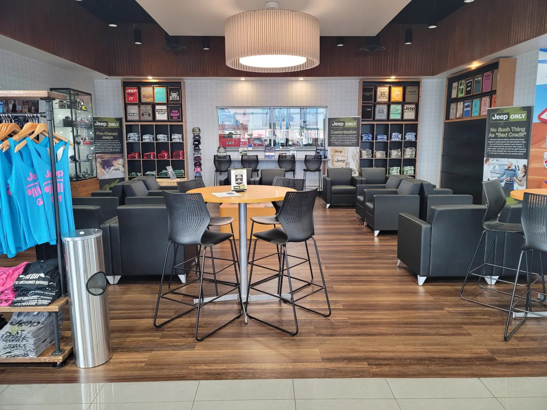 Jeep Only customer lounge with seating, apparel displays, and pre-owned Jeep information signage inside the Las Vegas showroom