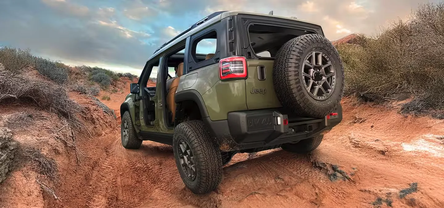 Green two-door Jeep Wrangler climbing a red rock ledge, the kind of terrain Las Vegas Jeep owners drive