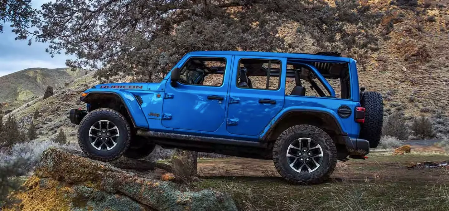 Blue Jeep Wrangler Rubicon climbing rocky terrain for Jeep Wrangler shoppers in Las Vegas