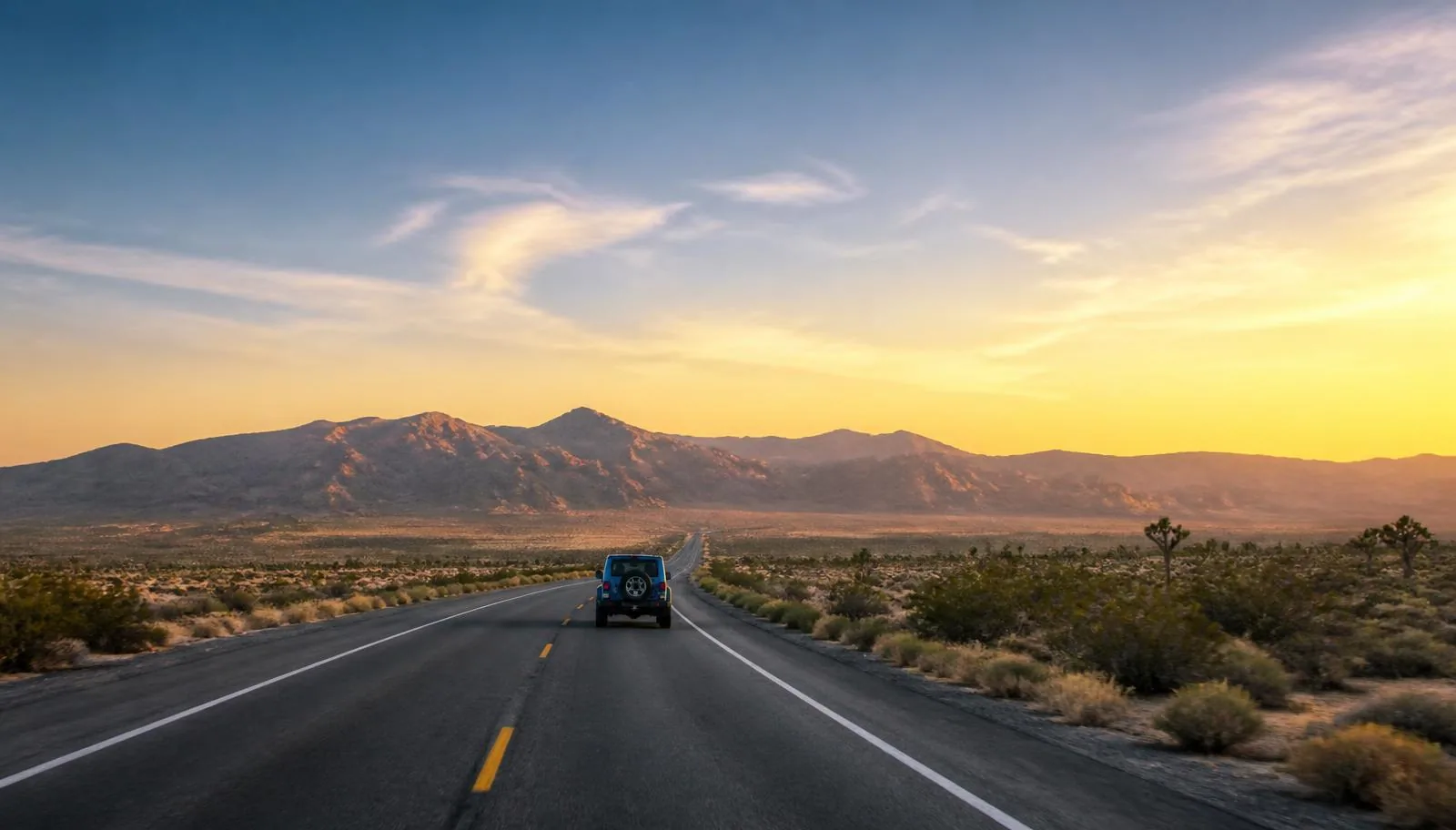 Jeep Wrangler driving across a desert highway near Las Vegas for a Wrangler vs Bronco comparison