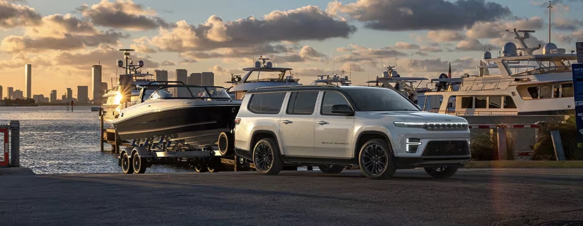 2026 Jeep Grand Wagoneer with a trailer attached, rear three-quarter view
