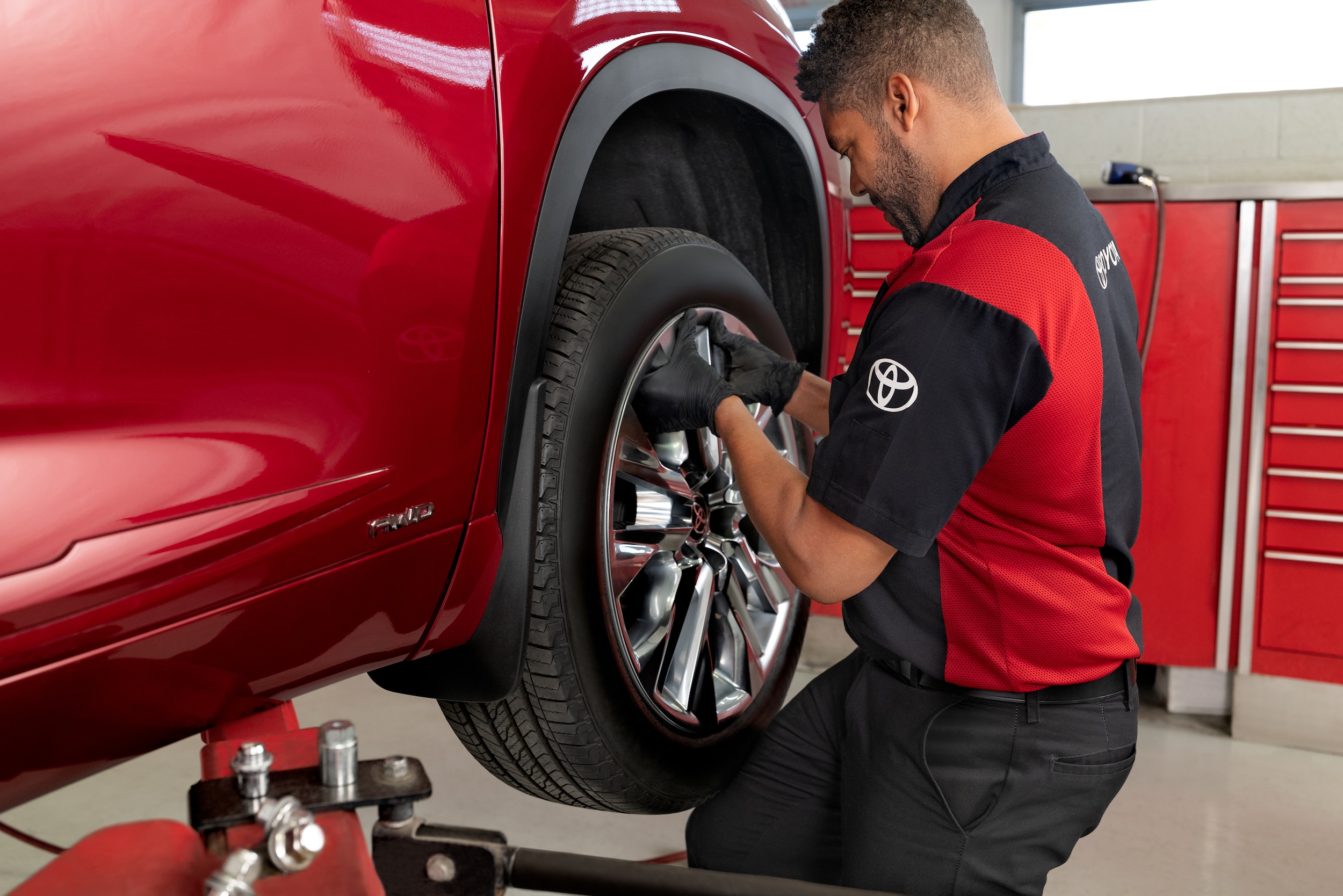 Service technician putting on a new Toyota tire.
