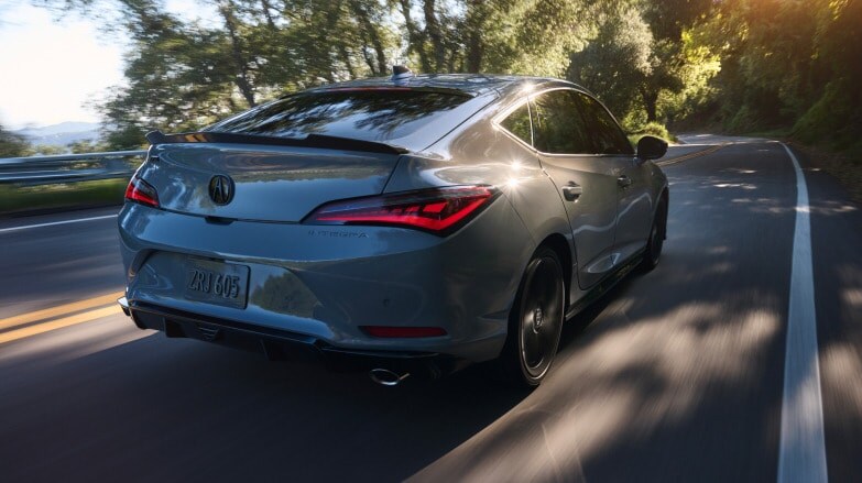 A rear view of a gray Acura Integra driving down the road A rear view of a gray Acura Integra driving down the road