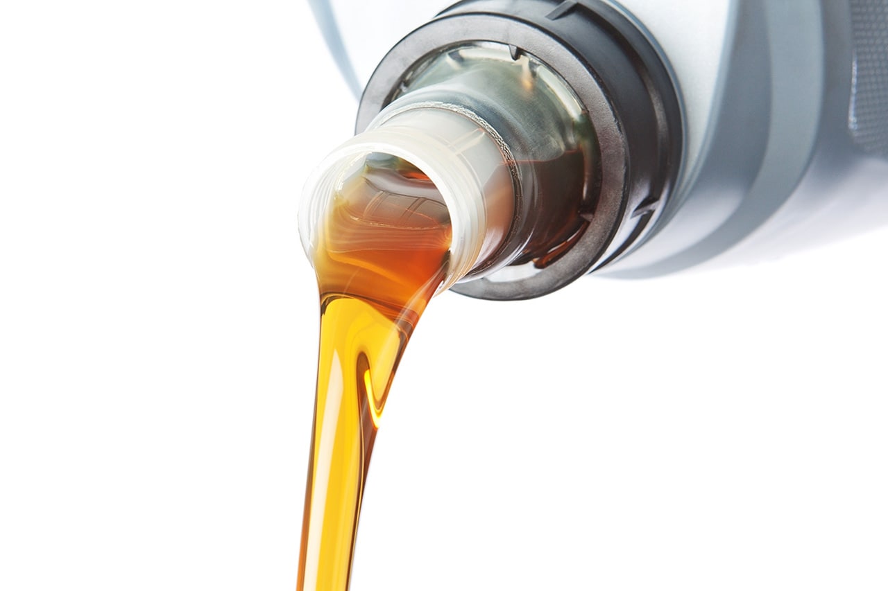 oil being poured in front of white background