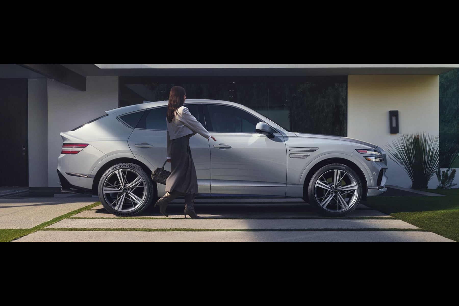 Silver 2026 Genesis GV80 Coupe parked with a woman