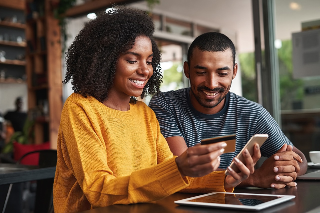Happy couple at a computer with a gift card