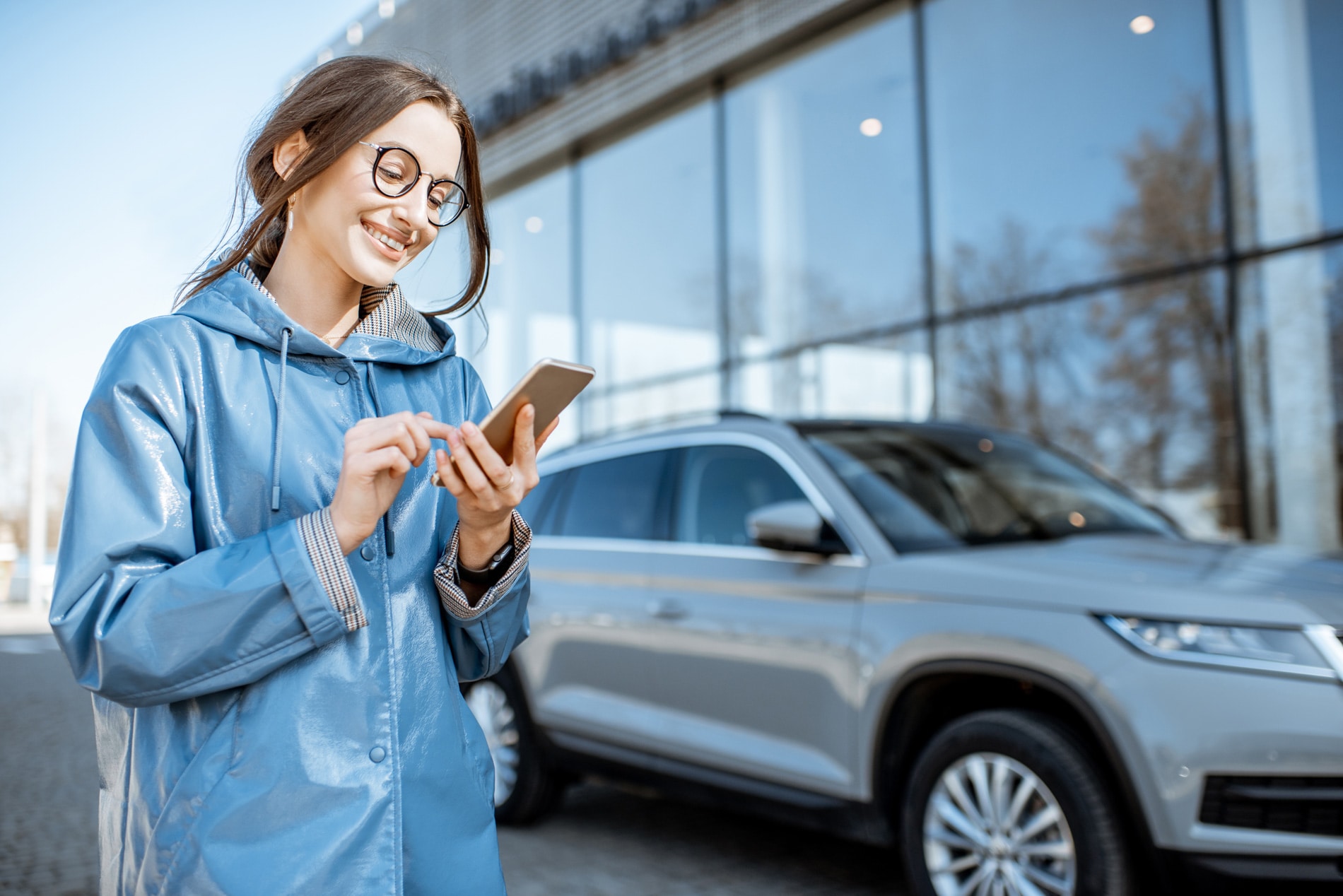 Car shopping woman using her smartphone