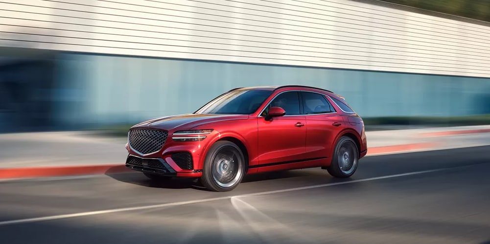Red 2025 Genesis GV70 cruising