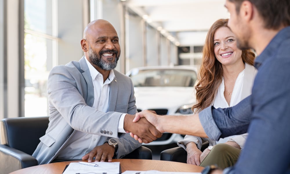 Man shaking hands in car dealership