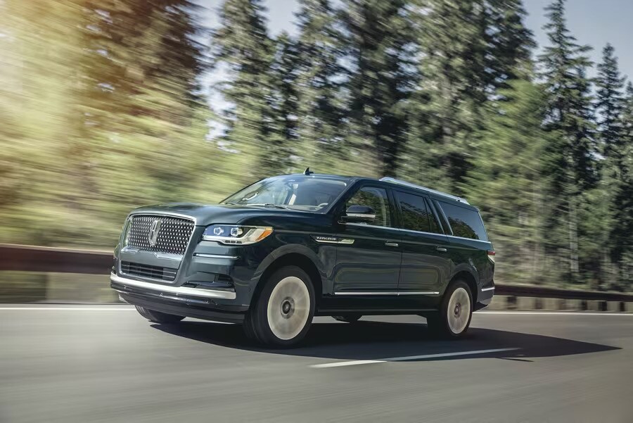 2024 Lincoln Navigator driving through forest on highway 