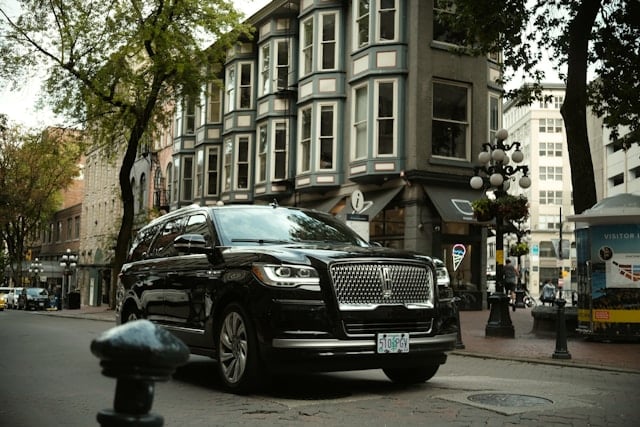 a black lincoln suv parked on the side of the road